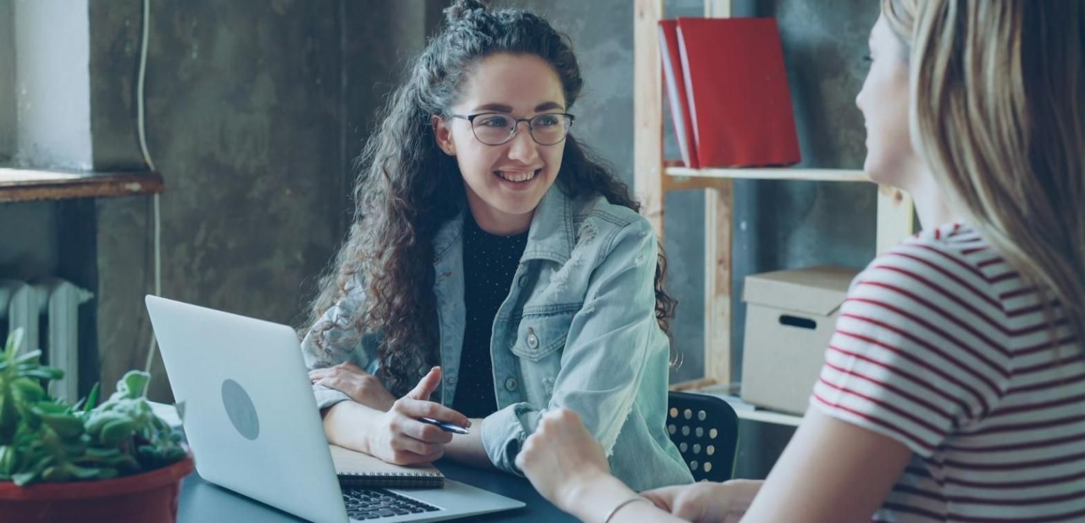 Reunión de trabajo alrededor de una mesa con un portátil